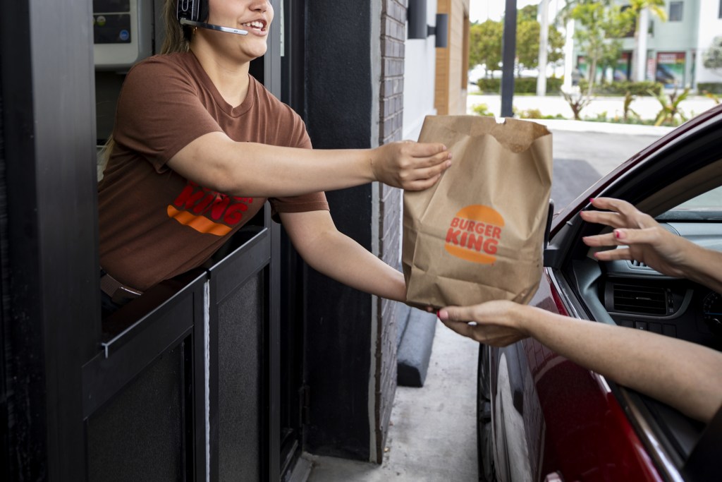 A worker hands food to a customer at the drive-thru window of a Burger King fast food restaurant in Hialeah, Florida, US, on Thursday, April 18, 2024. Restaurant Brands International Inc. is scheduled to release earnings figures on April 30. Photographer: Eva Marie Uzcategui/Bloomberg