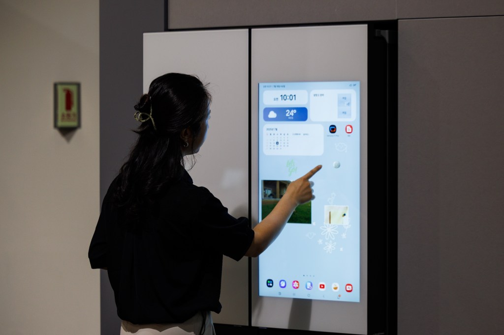 An employee demonstrates an AI refrigerator inside the Samsung Electronics Co. Innovation Museum at the company's headquarters in Suwon, South Korea, on Wednesday, July 16, 2025. Samsung is in talks with the likes of OpenAI Inc. and Perplexity AI Inc. to integrate more AI services in upcoming Galaxy devices, seeking a wider range of offerings beyond Google’s Gemini. Photographer: SeongJoon Cho/Bloomberg